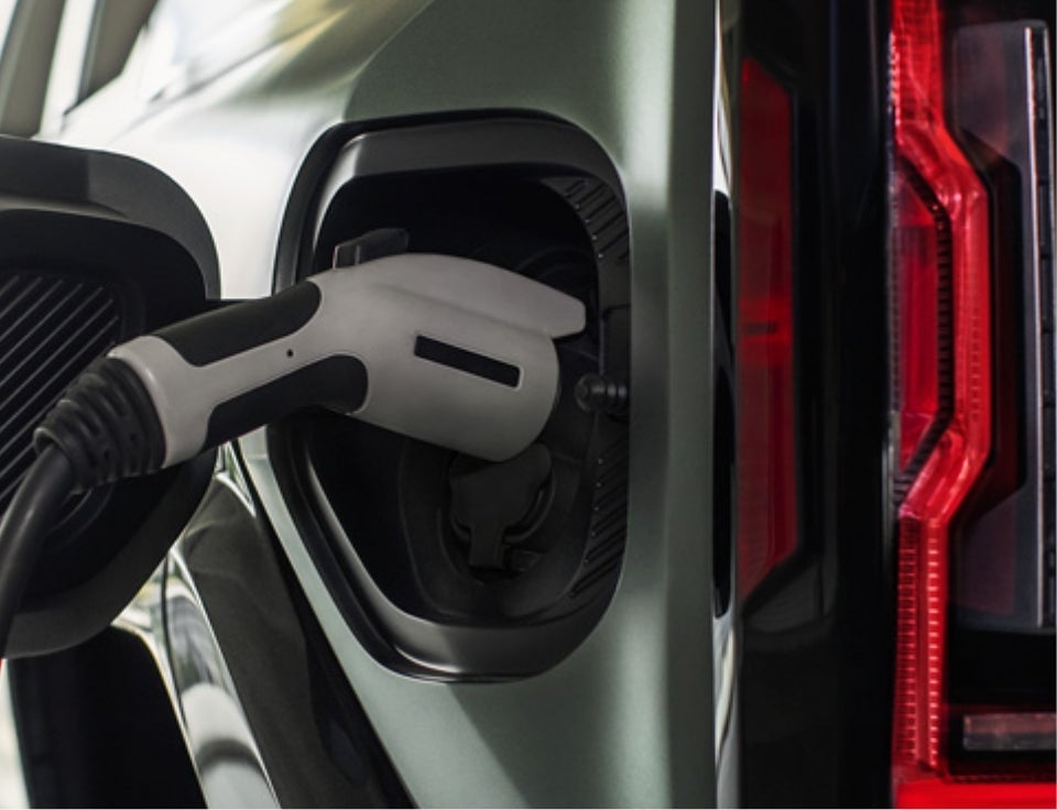 Close up of charging port with charger plugged in on a GMC Hummer EV SUV - Clift Buick GMC in Adrian MI